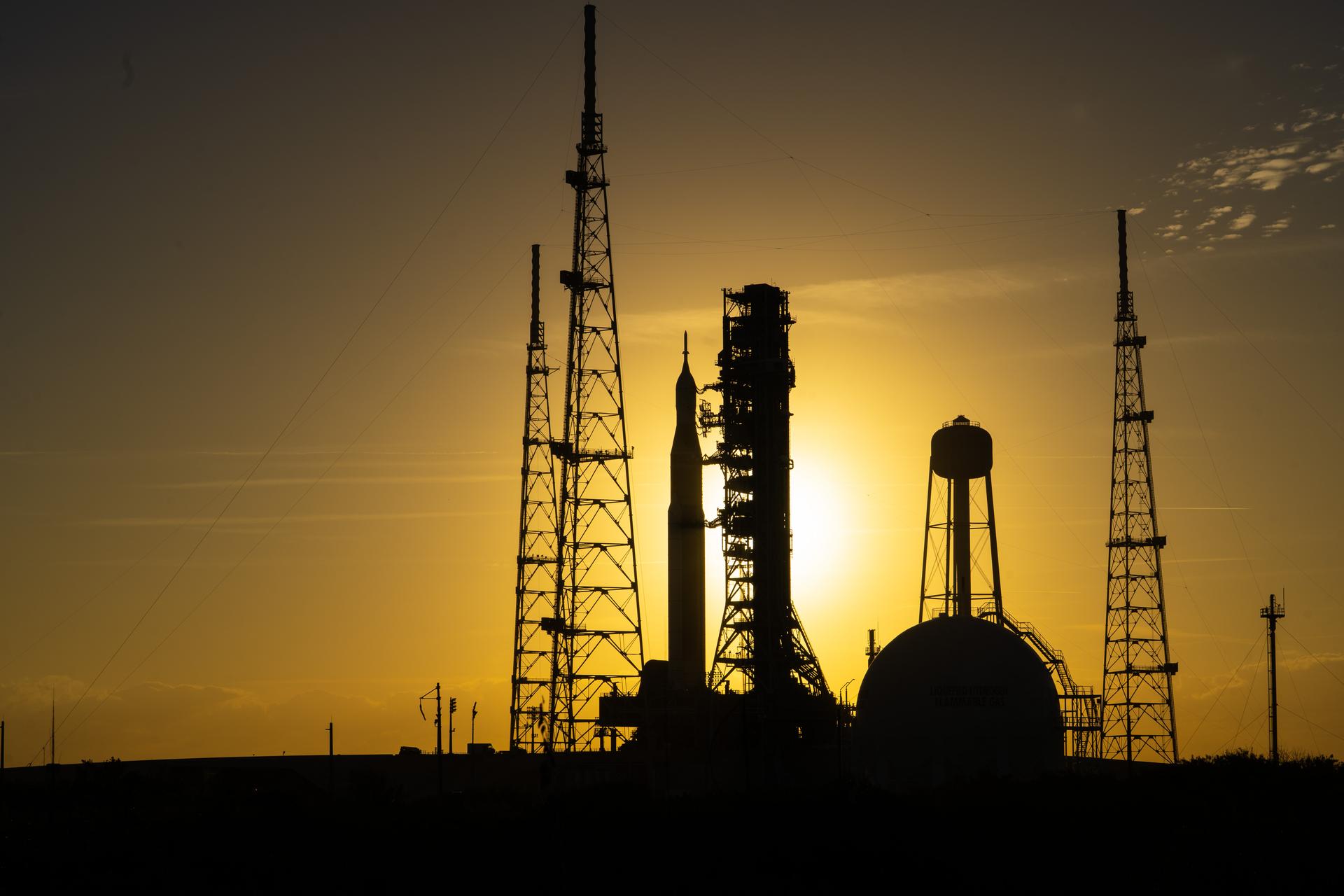 Il razzo SLS si trova al pad 39B in preparazione al lancio della missione Artemis II, mentre il sorge dietro di sè.